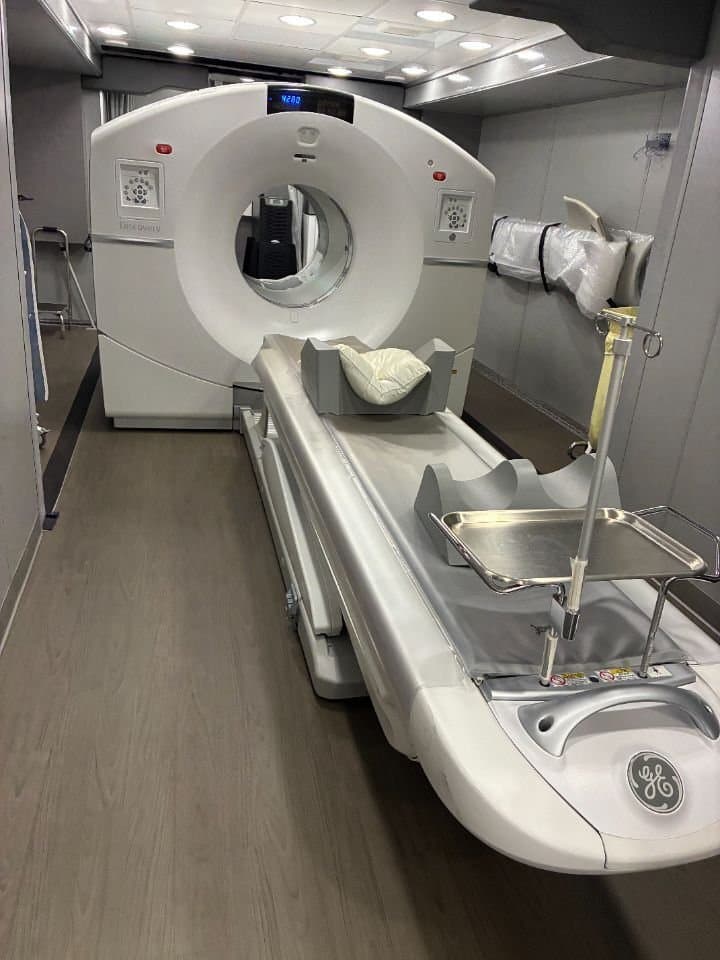 GE Discovery MI Gen2 30 cm, 6-ring (mobile). Scan room inside the trailer: gantry and patient table.